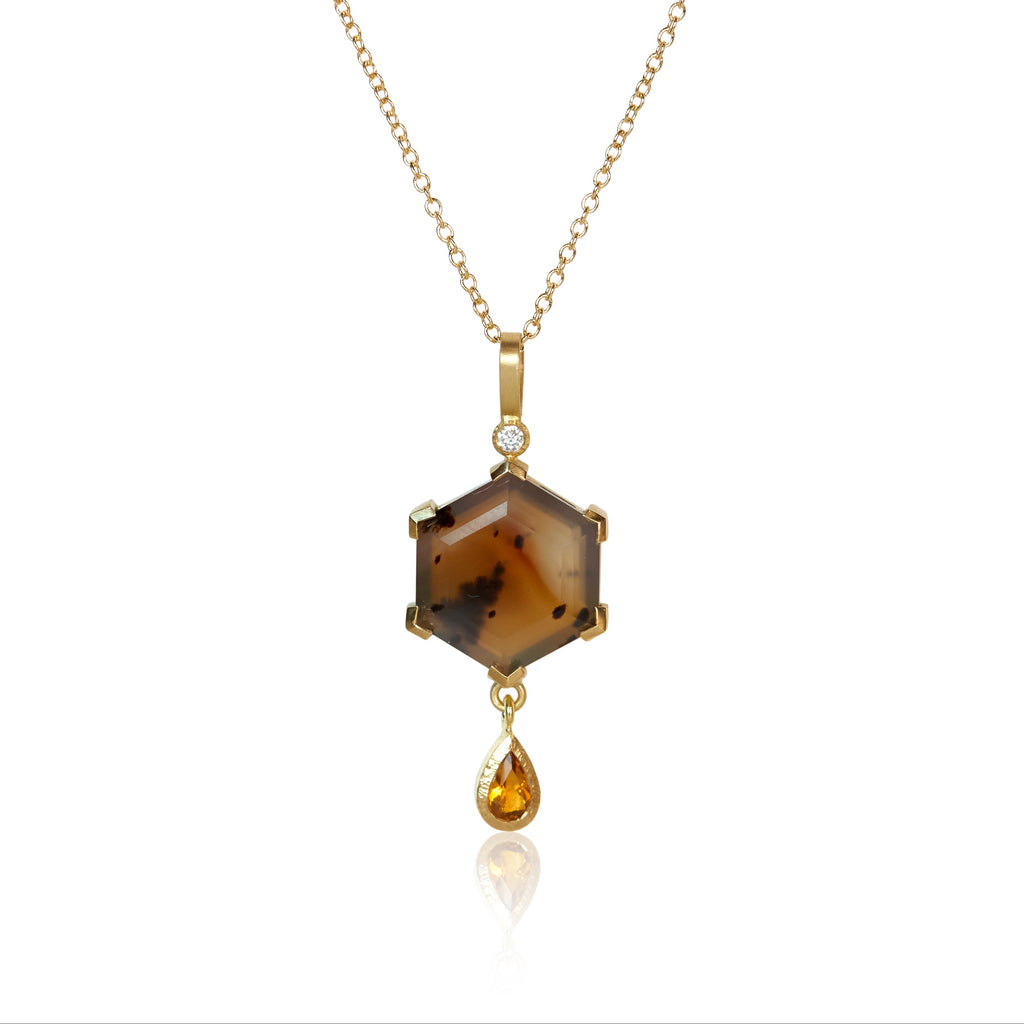 Pendant necklace with a hexagon Montana agate featuring natural inclusions, a pear-shaped golden citrine drop, and two small accent diamonds, set in Fairmined 18k yellow gold.