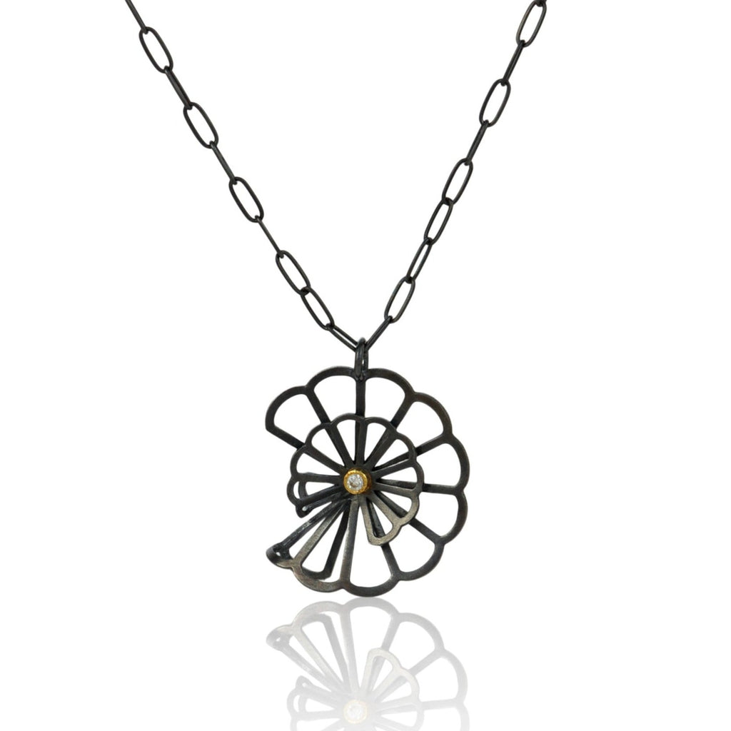 pendant in Karin Jacobson's Origami flower style made in oxidized sterling silver with a diamond set in 18k gold in the middle