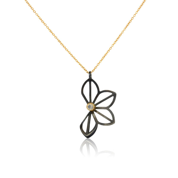 Karin Jacobson Jewelry's medium anise fold necklace with hyalite opal - it shows an oxidized sterling silver flower-like pendant with a 3mm faceted opal set in 18k gold - on 18k gold chain. photographed on white.