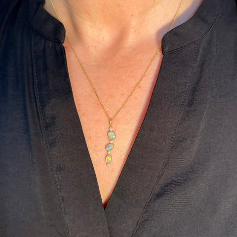 Karin Jacobson jewelry 3 opal and diamond pendant in 18k & 22k gold and sterling silver back, on 18k gold chain. Shown on a model.