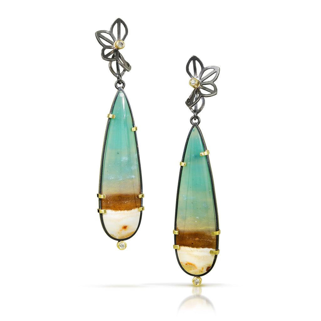 Photo of karin jacobson jewelry design opalized wood earrings with petite anise fold tops, in sterling silver and 18k yellow gold with 4 diamonds. The opalized wood is an elongated pear shaped teal green at the top and brown and cream color at the bottom.