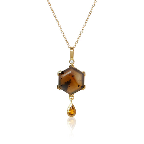 Pendant necklace with a hexagon Montana agate featuring natural inclusions, a pear-shaped golden citrine drop, and two small accent diamonds, set in Fairmined 18k yellow gold.