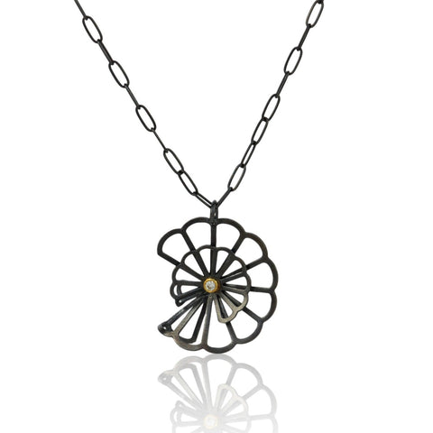 pendant in Karin Jacobson's Origami flower style made in oxidized sterling silver with a diamond set in 18k gold in the middle
