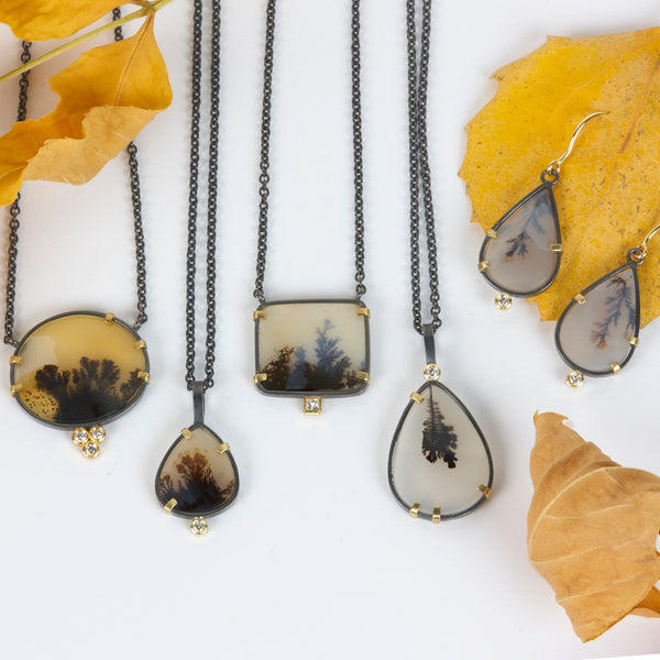 Pair of pear-shaped dendritic agate drop earrings in oxidized sterling silver with 18k yellow gold prongs, each accented with a small diamond below and finished with 18k gold French wires. Shown with 4 other pendants and yellow autum leaves.