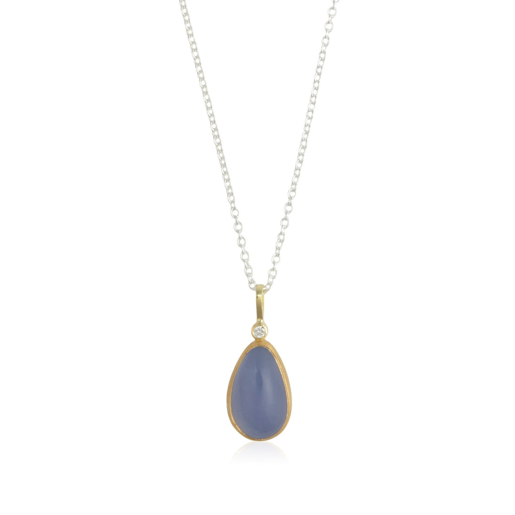 Photo of karin jacobson jewelry design pear shaped chalcedony cabochon and diamond necklace in sterling silver, 22k & 18k yellow gold. It has one diamond at the top of the pendant. Shown hanging from a silver chain.