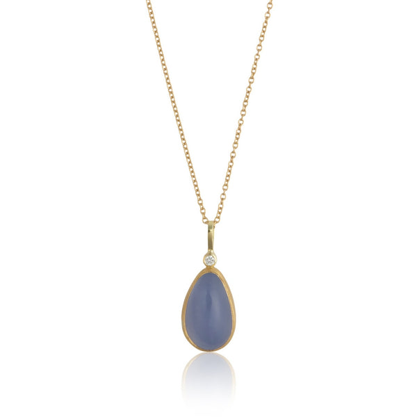 Photo of karin jacobson jewelry design pear shaped chalcedony cabochon and diamond necklace in sterling silver, 22k & 18k yellow gold. It has one diamond at the top of the pendant. Shown hanging from a gold chain.