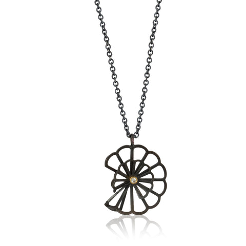pendant in Karin Jacobson's Origami flower style made in oxidized sterling silver with a diamond set in 18k gold in the middle