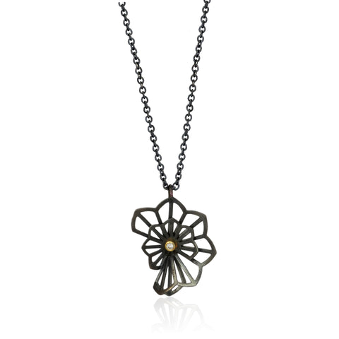 pendant in Karin Jacobson's Origami flower style made in oxidized sterling silver with center diamond set in 18k gold
