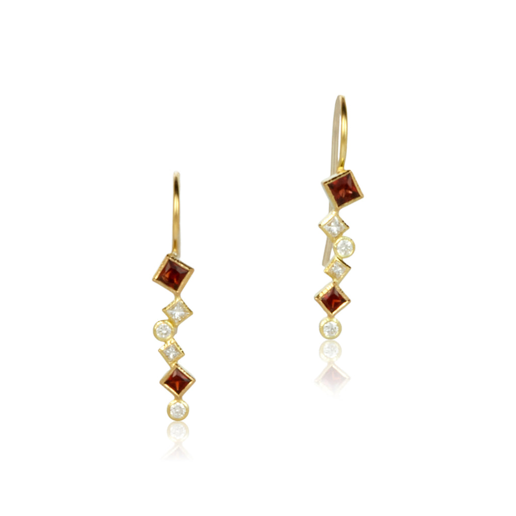 The photo shows 18k yellow gold confetti dangle earrings with various square and round rusty red garnets and diamonds on a white background.