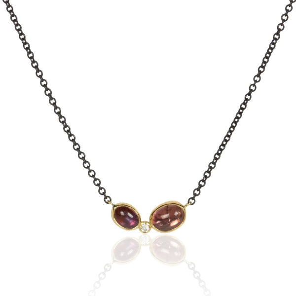 Necklace with two oval Umba sapphires and a small diamond between them, set in recycled 18k yellow gold on an oxidized silver cable chain. 