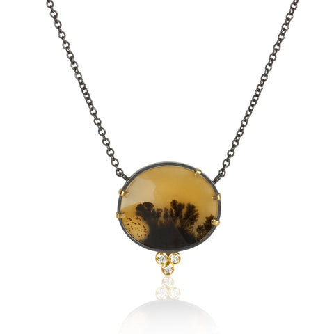 Round dendritic agate pendant in oxidized sterling silver with 18k yellow gold prongs and a cluster of three small diamonds below, shown on an oxidized silver cable chain.