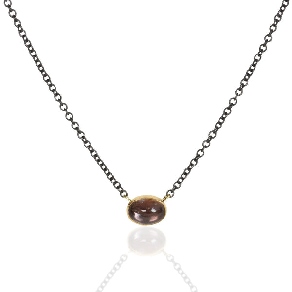 Small oval Umba sapphire pendant in recycled 18k yellow gold on an oxidized silver cable chain.