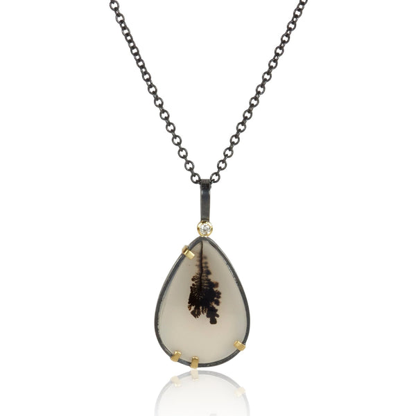 Pear-shaped dendritic agate pendant in oxidized sterling silver with 18k yellow gold prongs and a small diamond accent above, shown on an oxidized silver cable chain.