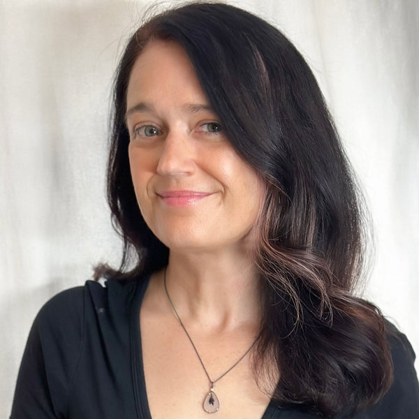 Pear-shaped dendritic agate pendant in oxidized sterling silver with 18k yellow gold prongs and a small diamond accent above, shown on an oxidized silver cable chain. Shown on a model.