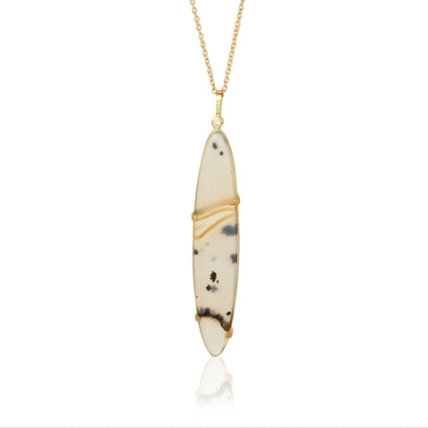 Elongated oval Montana agate pendant in Fairmined 18k yellow gold with diamond accent, featuring golden bands and dark speckles.