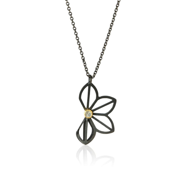 Karin Jacobson Jewelry's medium anise fold necklace with hyalite opal - it shows an oxidized sterling silver flower-like pendant with a 3mm faceted opal set in 18k gold. photographed on white.