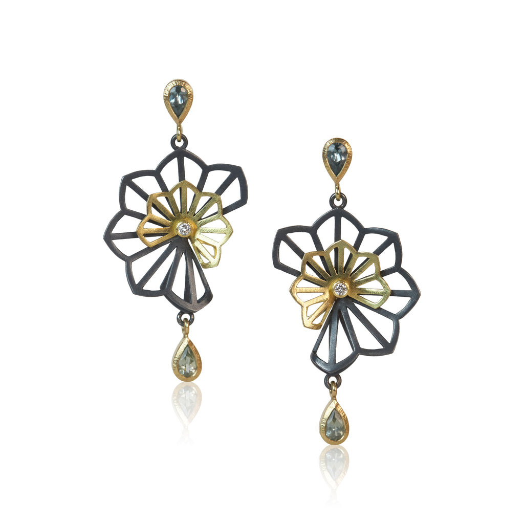 Sculptural Double Hyacinth Fold earrings in oxidized sterling silver and 18k yellow gold, with overlapping openwork floral shapes, blue-green pear-shaped Montana sapphires, and recycled diamond centers.