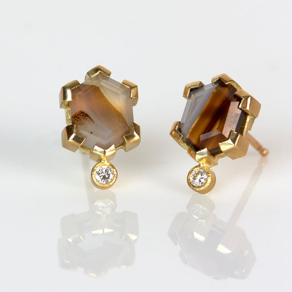 Pair of stud earrings with hexagon-cut Montana agates in shades of brown and gray, each accented by a small round diamond, set in Fairmined 18k yellow gold.