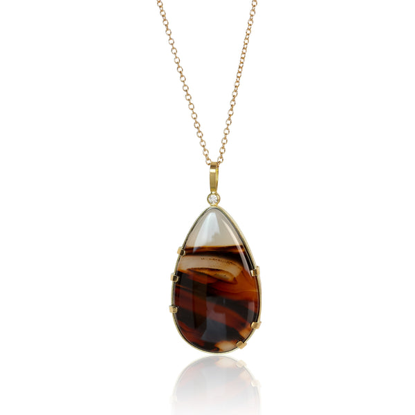 Teardrop-shaped Montana agate pendant in Fairmined 18k yellow gold with .025 ct diamond, featuring dark brown swirls and translucent white at the top.