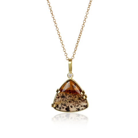 Triangular Montana agate pendant in Fairmined 18k yellow gold with .025 ct diamond, featuring amber tones, cream layers, and dark speckles.