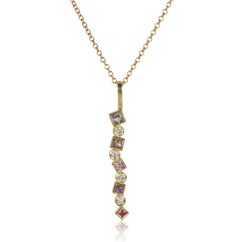 18k gold pendant with a vertical line of pink sapphires arranged in a deepening ombré (totaling .31 ct) alongside scattered post-consumer recycled diamonds totaling .12 ct, shown on an 18k gold cable chain.