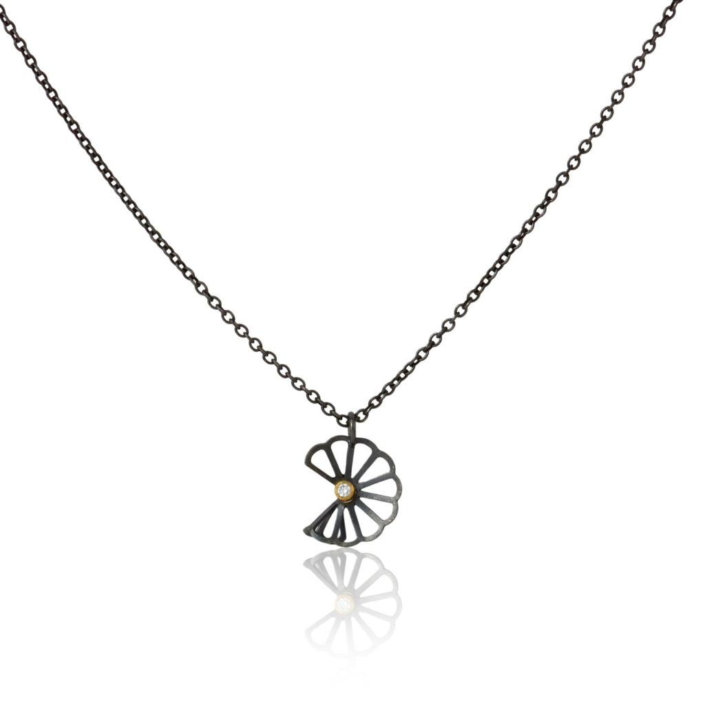 Karin Jacobson Jewelry's petite cloud fold necklace with tiny diamond - it shows an oxidized sterling silver flower-like pendant with a 2mm diamond set in 18k gold, on an oxidized sterling chain. photographed on white.