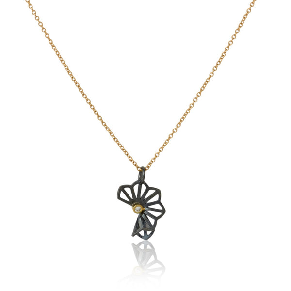 Karin Jacobson Jewelry's petite hyacinth fold necklace with tiny diamond - it shows an oxidized sterling silver flower-like pendant with a 2mm diamond set in 18k gold, on an 18k gold chain. photographed on white.