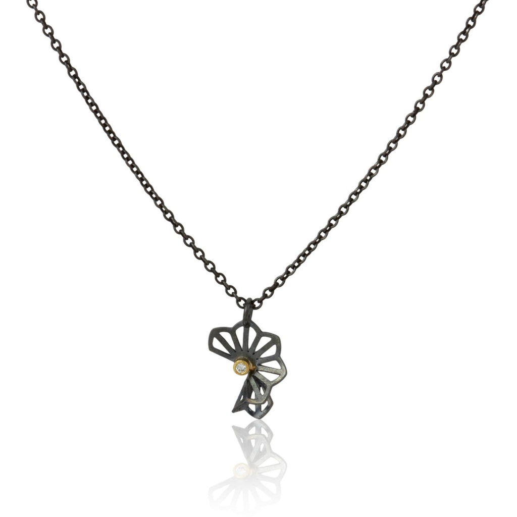 Karin Jacobson Jewelry's petite hyacinth fold necklace with tiny diamond - it shows an oxidized sterling silver flower-like pendant with a 2mm diamond set in 18k gold, on an oxidized sterling chain. photographed on white.