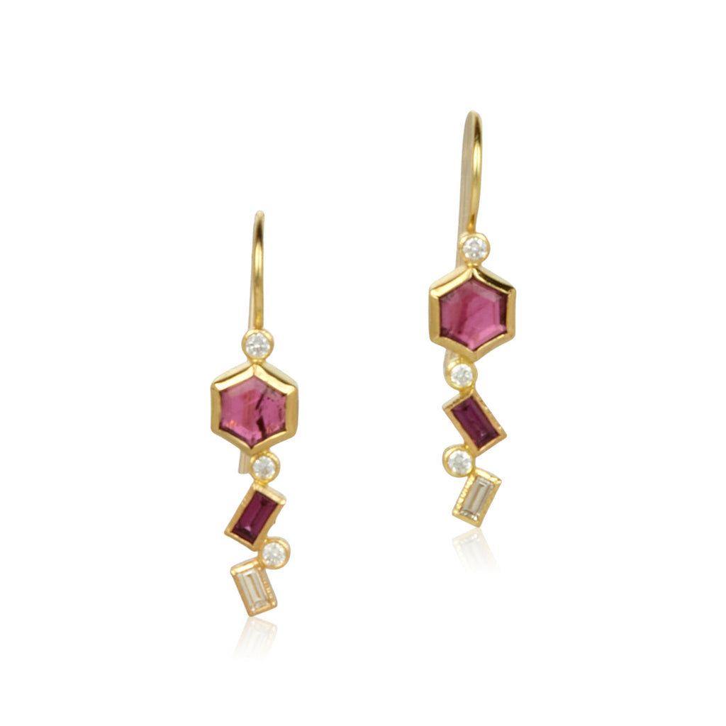 The photo shows 18k yellow gold confetti dangle earrings with hexagon cut pink tourmalines, baguette (rectangle) cut grape garnets, and round & baguette cut diamonds on a white background.