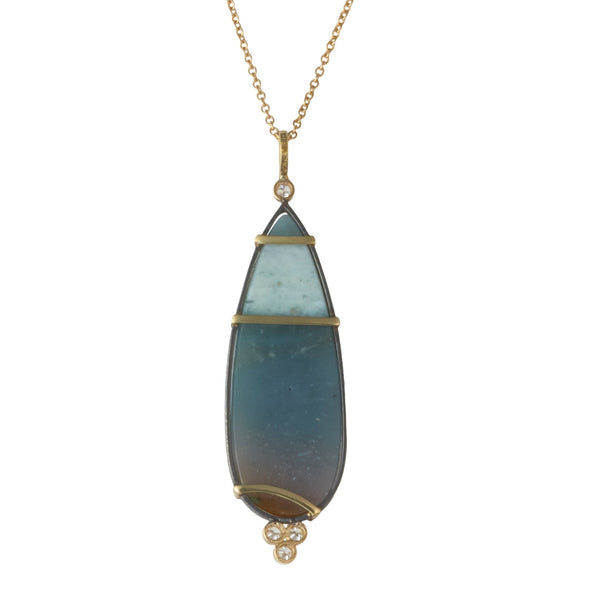 Photo of karin jacobson jewelry design opalized wood and diamond necklace in sterling silver and 18k yellow gold, shown hanging from a gold chain. back side shown