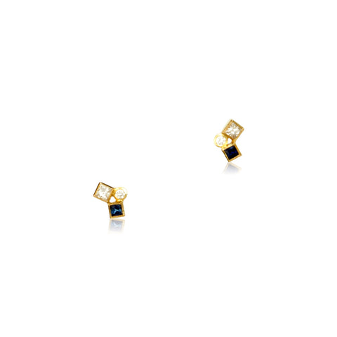 Shows a pair of dark blue sapphire and diamond studs on white. Each stud has one square diamond, one square blue sapphire and one round diamond.
