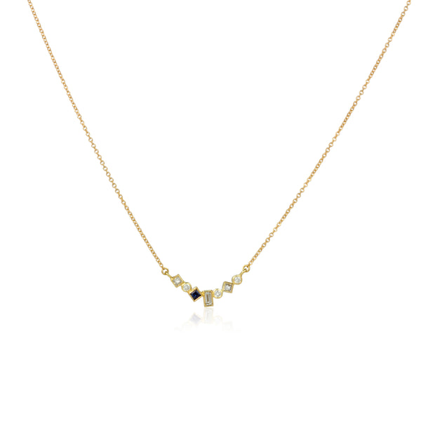 Shows an 18k yellow gold confetti necklace with various square, rectangle and round diamonds with one dark blue square sapphire, hanging from a gold cable chain on a white background.