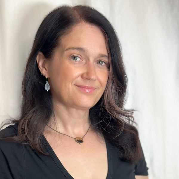 Round dendritic agate pendant in oxidized sterling silver with 18k yellow gold prongs and a cluster of three small diamonds below, shown on an oxidized silver cable chain. Shown on a model