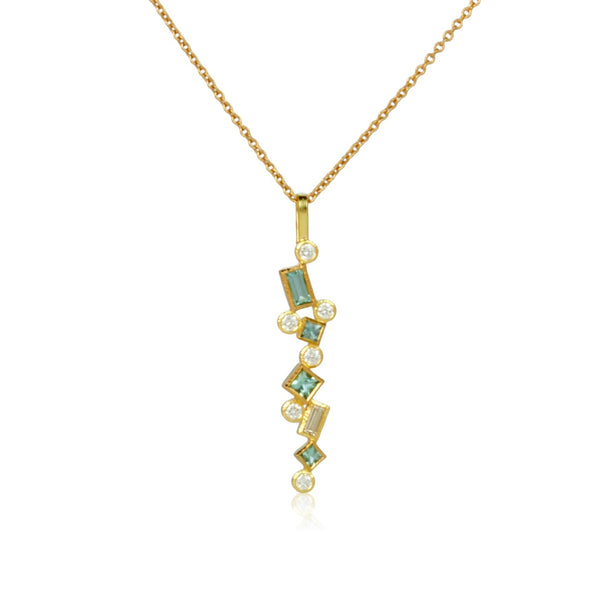 Shows an 18k yellow gold confetti necklace with various square, rectangle and round seafoam (pale green) tourmalines and diamonds, hanging from a gold cable chain on a white background - close up shot.
