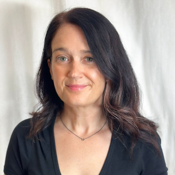 Small oval Umba sapphire pendant in recycled 18k yellow gold on an oxidized silver cable chain. Shown on model