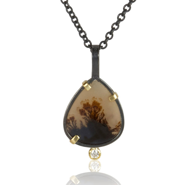 Small pear-shaped dendritic agate pendant in oxidized sterling silver with 18k yellow gold prongs and a single diamond accent below, shown on an oxidized silver cable chain.