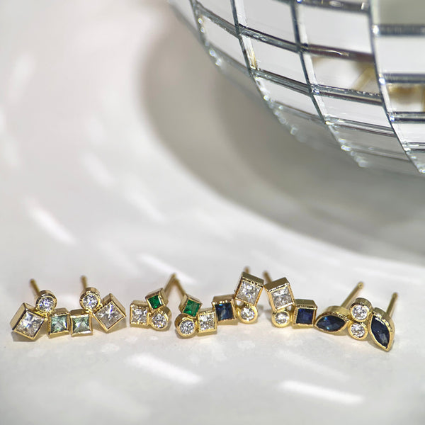 The photo shows 4 pairs of confetti studs next to a mirrored disco ball - from left to right: seafoam tourmaline and diamond; emerald and diamond; sapphire and diamond; marquise sapphire and diamond.