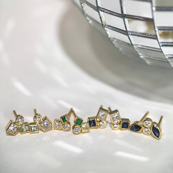 The photo shows 4 pairs of confetti studs next to a mirrored disco ball - from left to right: seafoam tourmaline and diamond; emerald and diamond; sapphire and diamond; marquise sapphire and diamond.