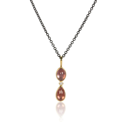 Vertical pendant with two Umba sapphires and a small diamond between them, set in recycled 18k yellow gold on an oxidized silver cable chain.