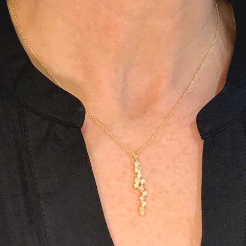 diamond confetti pendant on gold chain on model